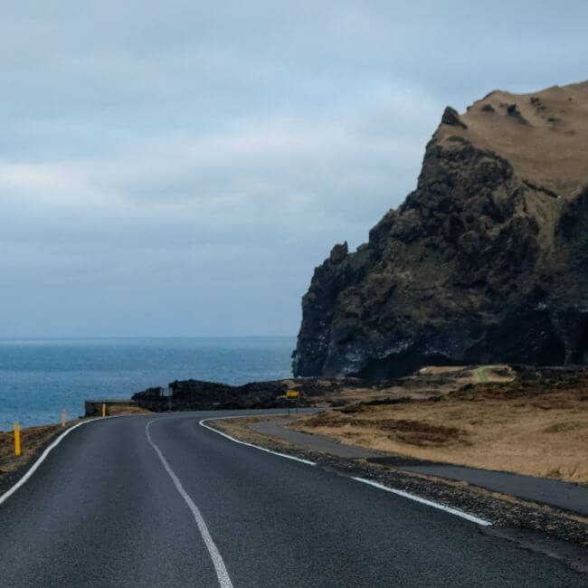Road, mountain and sea in the background